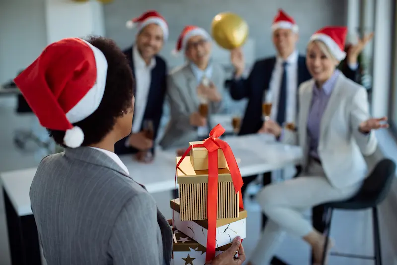 empresaria-sorprendiendo-sus-colegas-con-regalos-de-navidad-corporativo-en-la-oficina