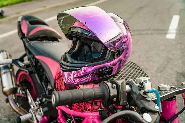 Casco negroy rosado encima de una motocicleta